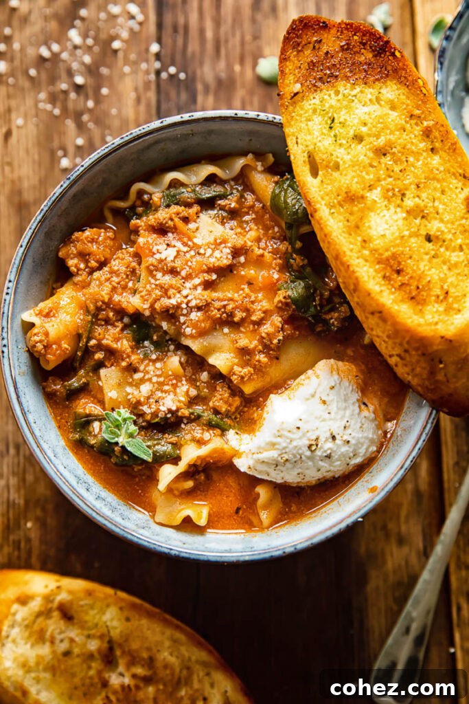 bowl of lasagna soup with a piece of garlic bread