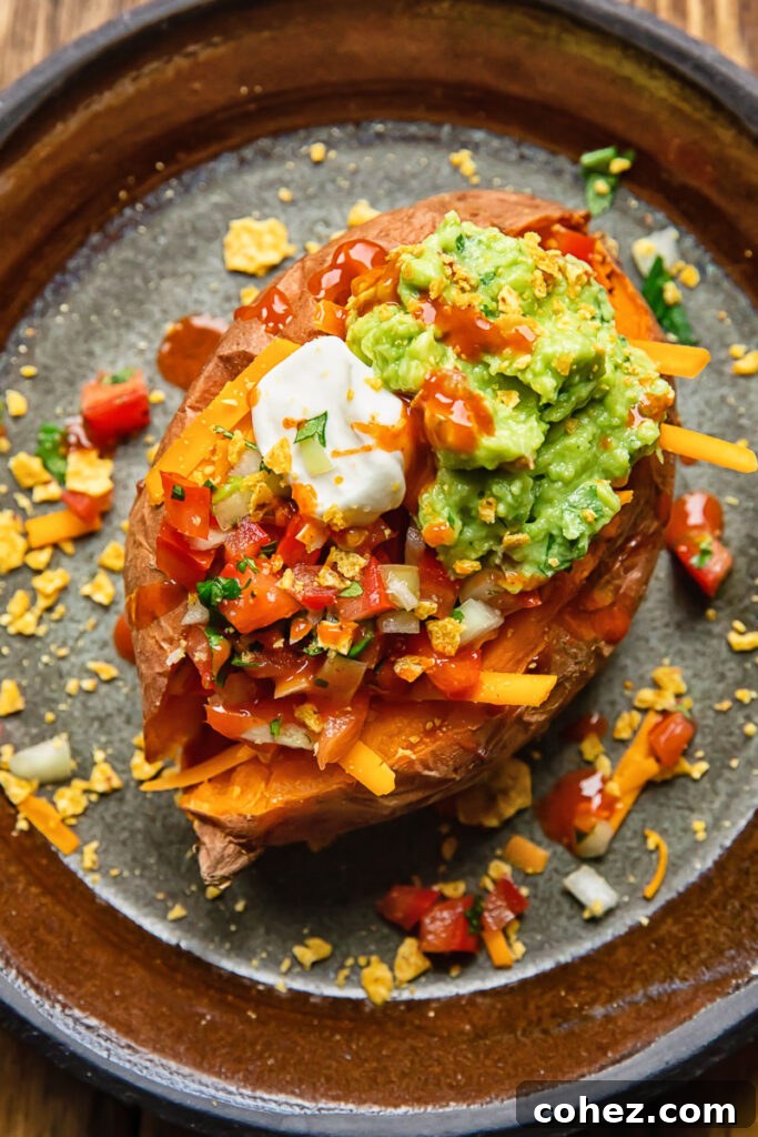 Top-down view of a baked potato generously loaded with creamy sour cream, vibrant guacamole, and zesty salsa toppings, capturing the essence of a Tex-Mex inspired meal.