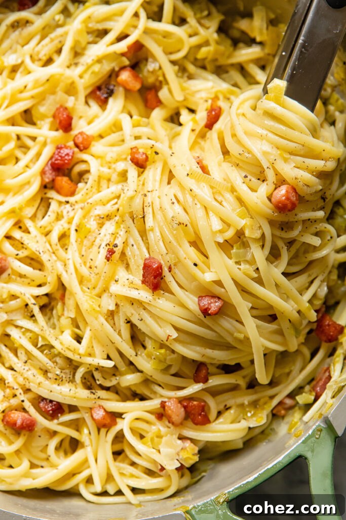 Close up of creamy leek and pancetta pasta in a pan, showcasing its rich texture