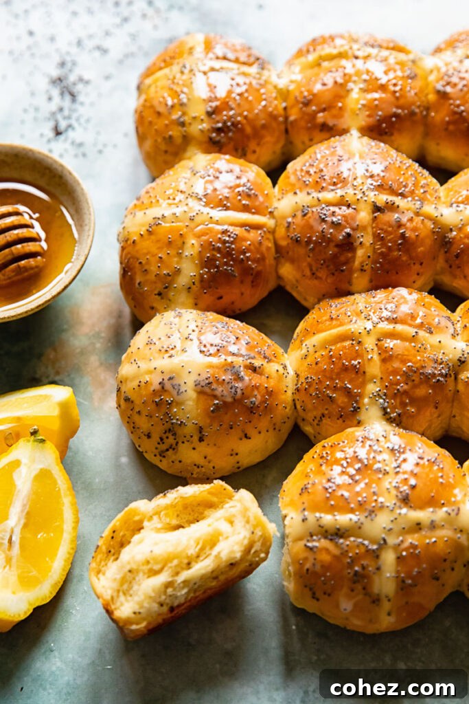Sunshine Lemon Poppy Seed Hot Cross Buns 3 Close up of hot cross buns, one sliced open to reveal its fluffy, tender interior.