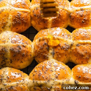 honey being drizzled on top of a hot cross bun
