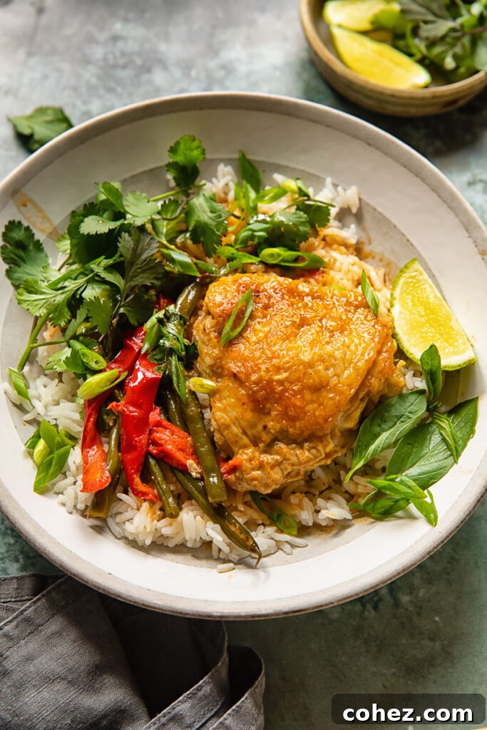 the coconut curry in a bowl with rice and chicken thigh