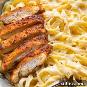 Top down shot of tagliatelle in alfredo sauce topped with blacken chicken strips in a bowl
