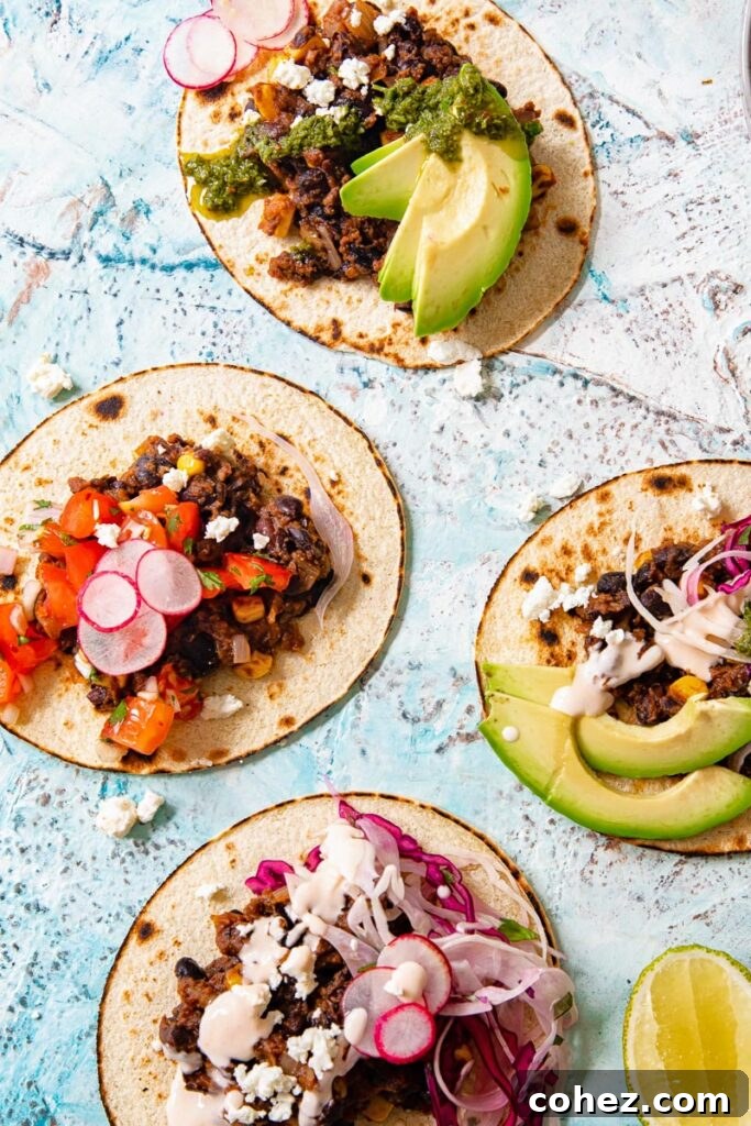 Black Bean Corn Tacos with Zesty Cilantro Lime Slaw 3 Four black bean and corn tacos lying open with a range of toppings including avocado, slaw, and radish