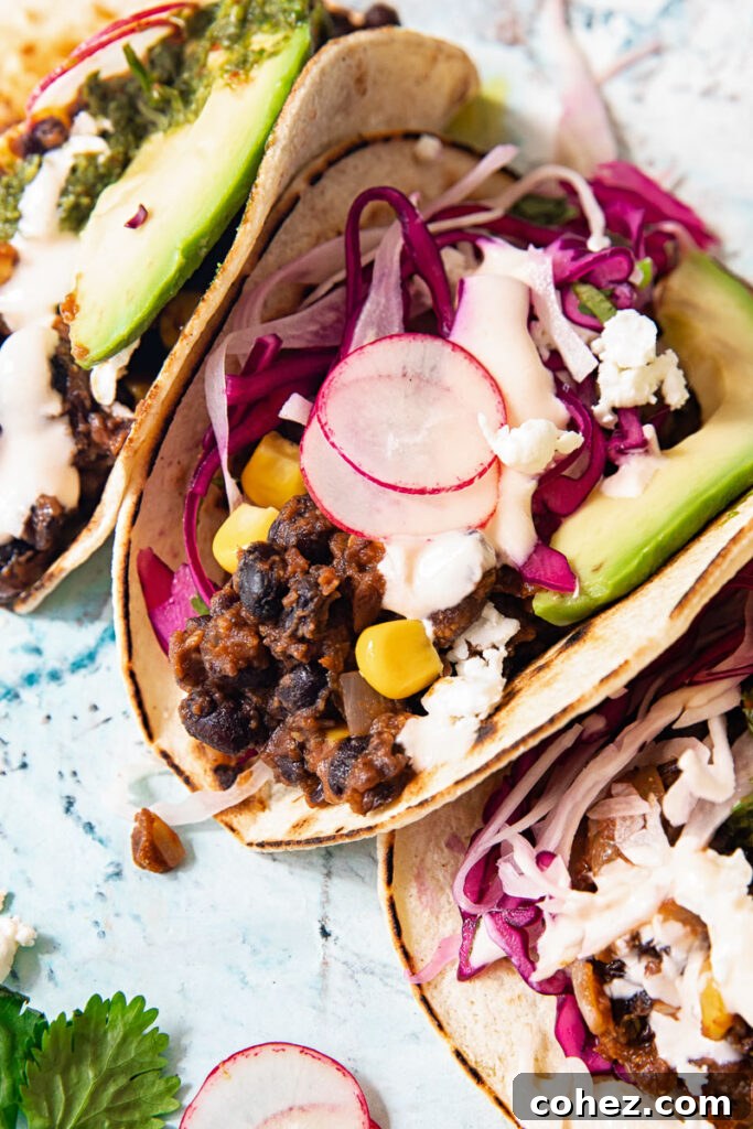 Black Bean Corn Tacos with Zesty Cilantro Lime Slaw 6 Close up of a black bean and corn taco showing radish, cilantro lime slaw, and a slice of avocado