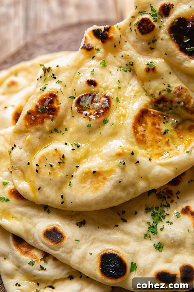 Naan Bread From Scratch 4 Top down shot of naan topped with herby garlic butter on a cutting board