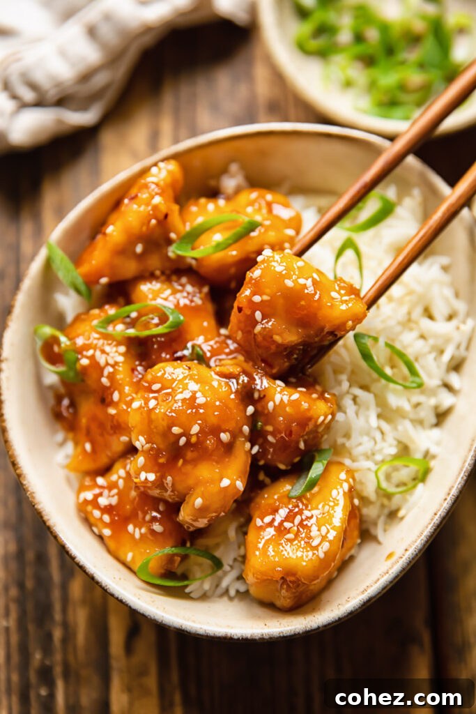 chopsticks removing piece of chicken from bowl of rice
