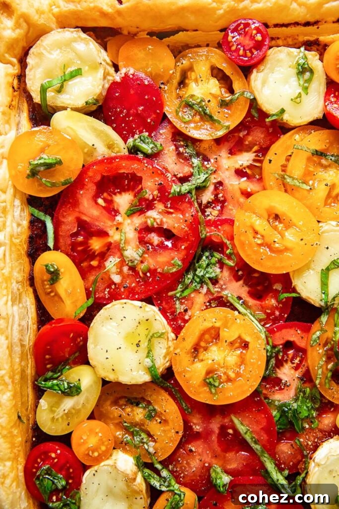 Summer Tomato and Goat Cheese Puff Pastry Tart 3 Close-up aerial view of the vibrant heirloom tomatoes carefully arranged on the baked tart, showcasing their rich colors and textures.