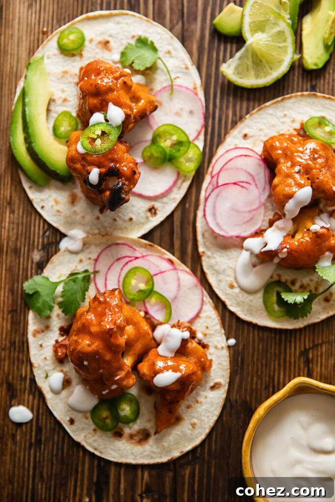 Buffalo cauliflower tacos with a vibrant assortment of fresh toppings arranged on a tabletop
