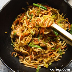 Top down view of a wok with vegetarian yaki udon noodles being stirred