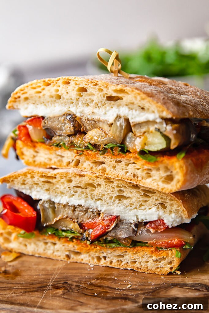 Gourmet Roasted Harvest Vegetable and Chèvre Sandwich 2 Close-up profile of a Gourmet Roasted Vegetable and Goat Cheese Sandwich on ciabatta bread, showcasing vibrant roasted vegetables and creamy goat cheese.