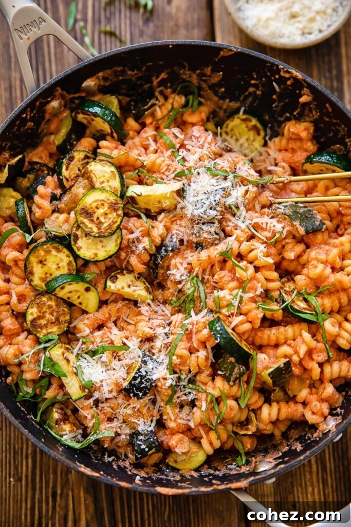 Creamy Tomato Ricotta & Zucchini Pasta for Summer 2 Top down shot of a skillet filled with creamy tomato pasta and golden fried zucchini
