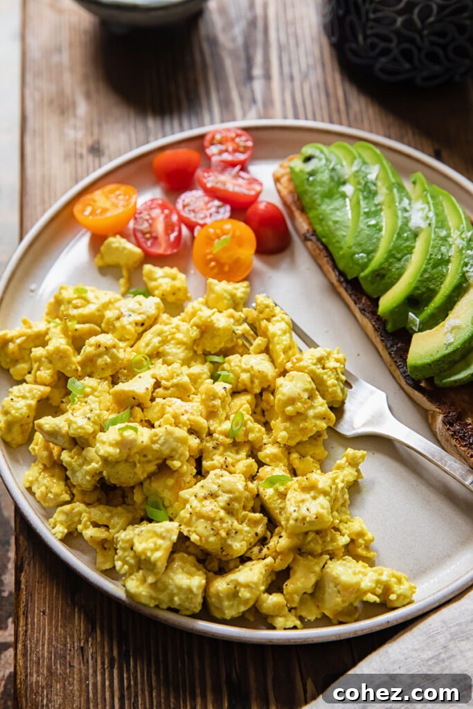 Plate of egg tofu scramble with vegetables and a fork