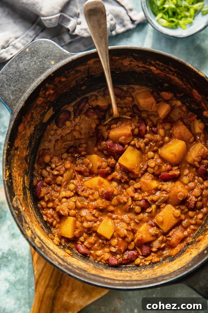 A top-down view of a generously portioned bowl of vegetarian chili, showcasing its rich texture and vibrant ingredients, ready to be enjoyed.