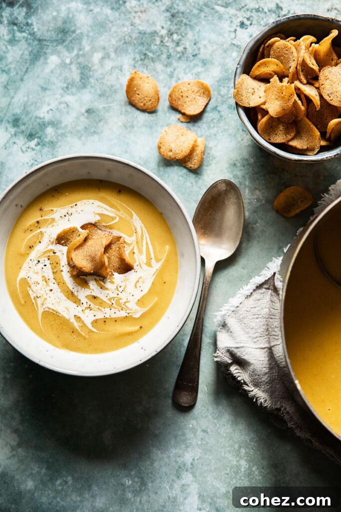 A rustic table spread featuring a large pot of curried roasted parsnip soup, served in a bowl with croutons, surrounded by fresh ingredients.