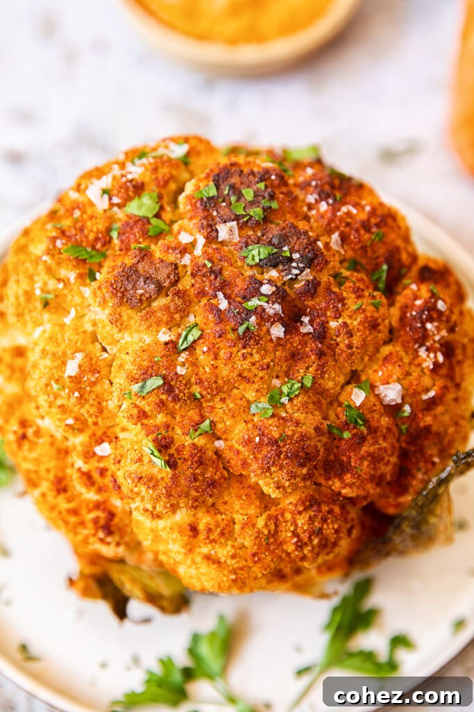 Close up of a perfectly roasted whole cauliflower head with golden-brown florets