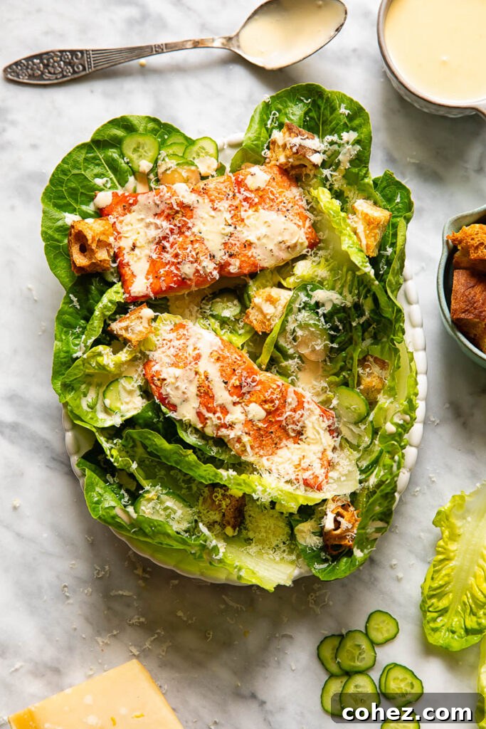 Regal Salmon Caesar 3 Top down shot of salmon Caesar salad on a small platter next to a bowl of croutons