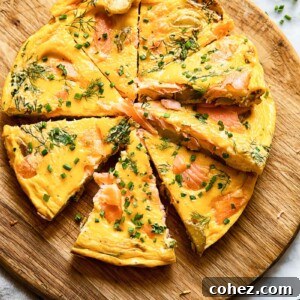 Top down shot of salmon frittata slices on a platter topped with herbs