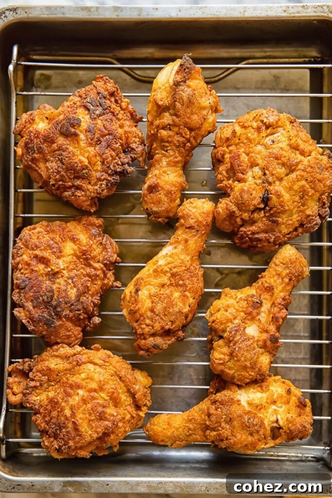 Top down shot of buttermilk fried chicken pieces cooling on a wire rack