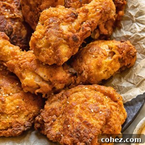 Close up shot of buttermilk fried chicken drumsticks with crispy skin piled on a plate