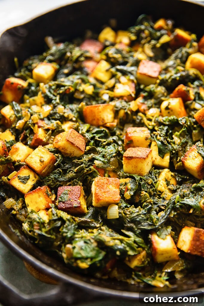 Heaps of vibrant green Saag Paneer in a cast iron pan, ready to serve.