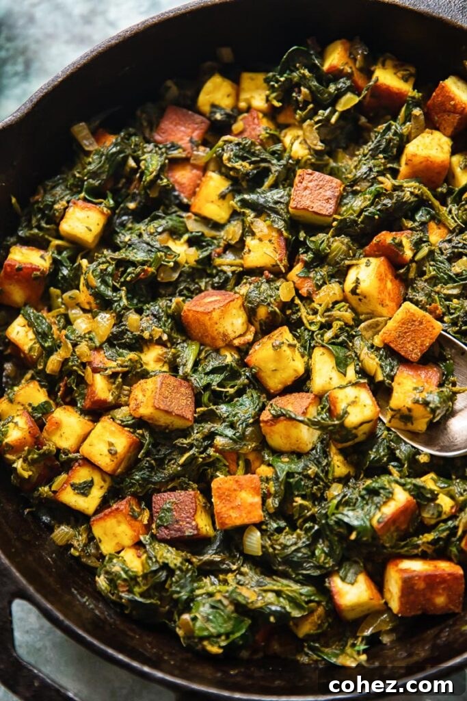 Top-down view of a cast iron pan filled with Saag Paneer, garnished with fresh cilantro.