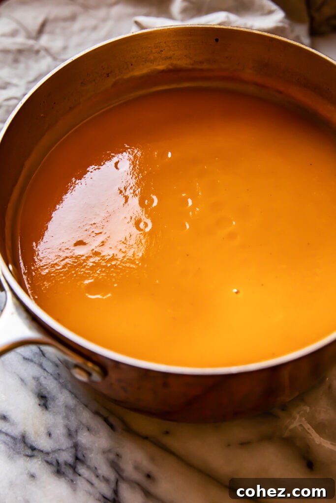 Zingy Sweet Potato Carrot Soup 3 A large pot of vibrant orange soup, ready to be served, showing off its rich and inviting color.