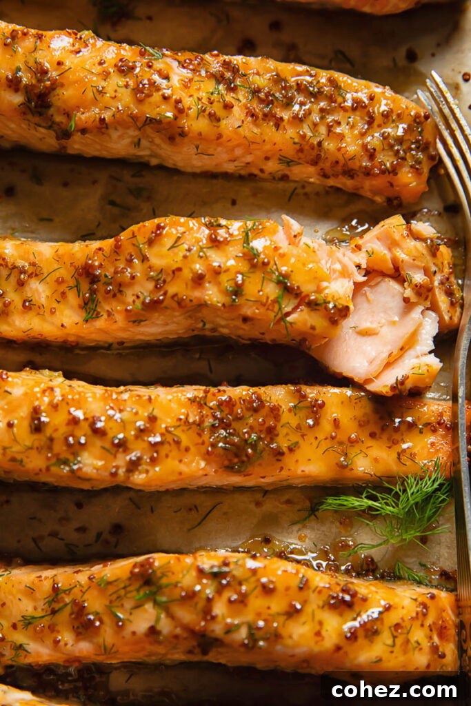 Close up shot of salmon fillets on a cooking tray topped with maple and mustard glaze