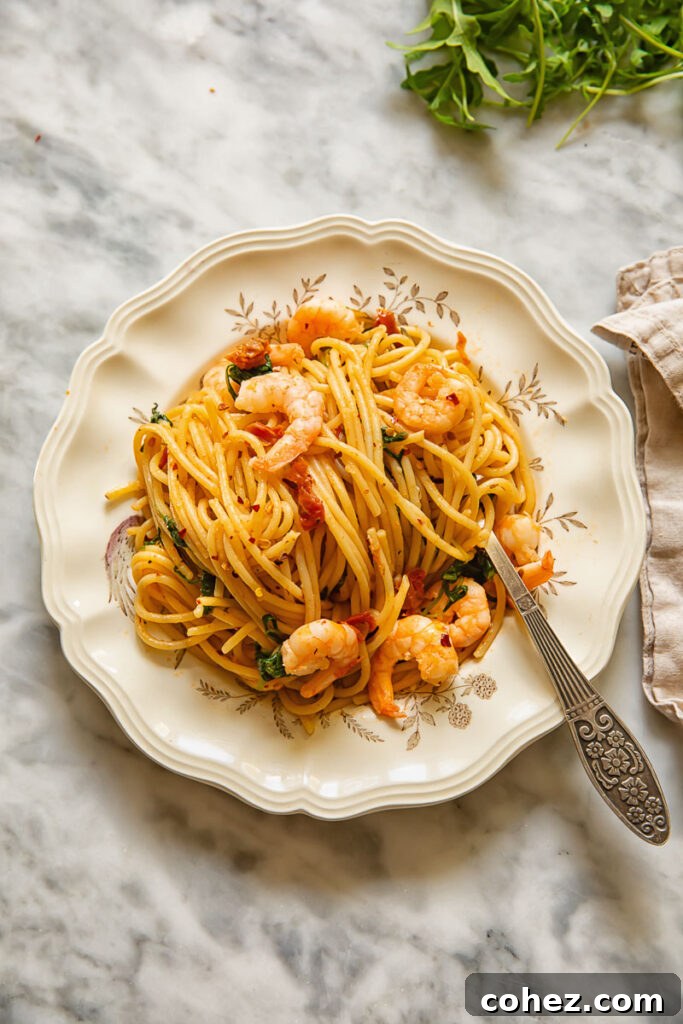 Top down shot of a fork with sun dried tomato spaghetti on a plate