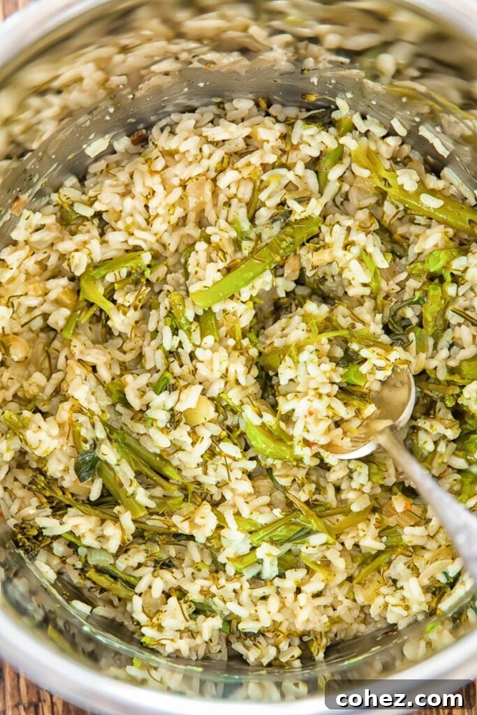 A close-up shot revealing the creamy texture of cooked risotto, speckled with tender pieces of vibrant green broccoli. The grains of rice are perfectly al dente, glistening with rich sauce.