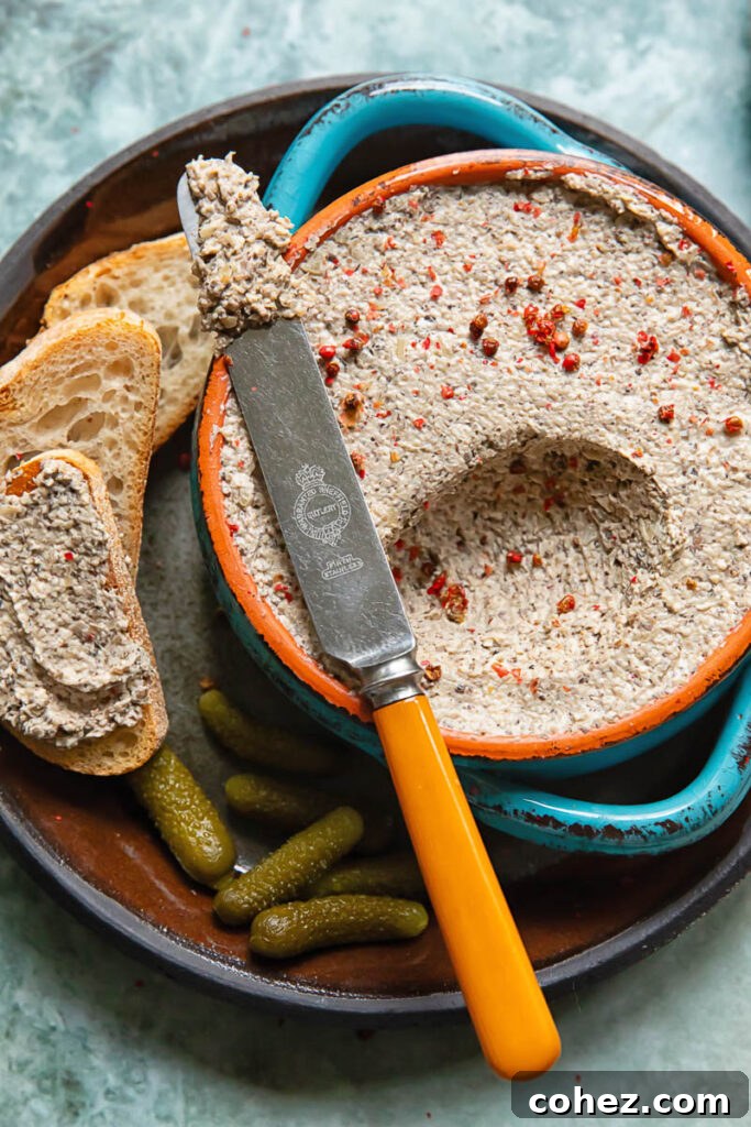 Close up shot of mushroom pâté being scooped out of a small bowl with a knife