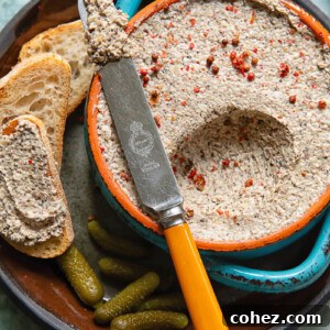 Close up shot of mushroom pâté being scooped out of a small bowl with a knife
