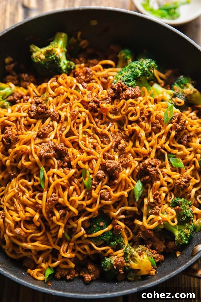 Shot of gochujang noodles in a pan with beef and broccoli