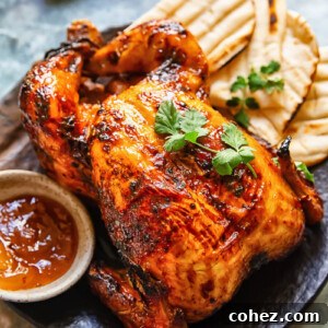 Top down shot of mango chutney roast chicken on a platter with naan bread topped with coriander