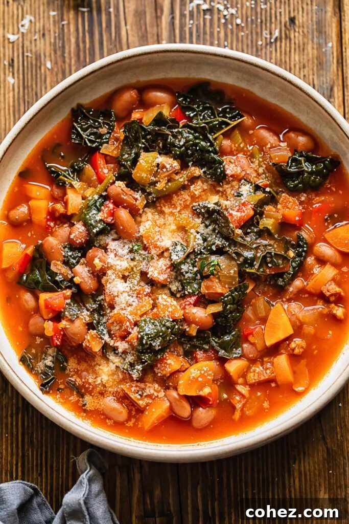Close up shot of chorizo bean and veg soup in a bowl topped with Parmesan