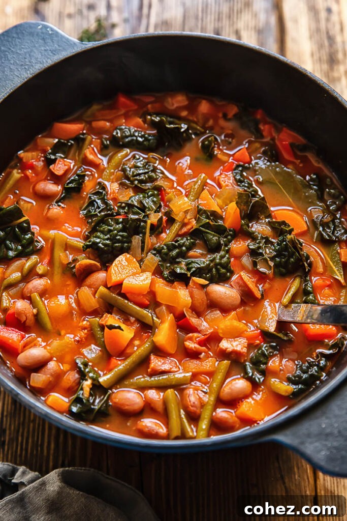 Top down shot of chorizo bean soup in a deep pot with a ladle