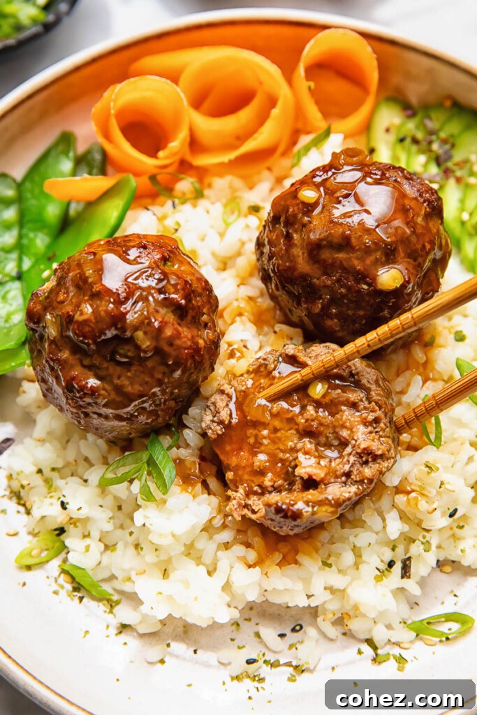 Sticky Sweet Teriyaki Meatballs 4 Close up shot of teriyaki meatballs served on top of a bowl of rice