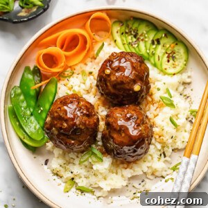 Close up shot of teriyaki meatballs with rice in a bowl with veg and chopsticks