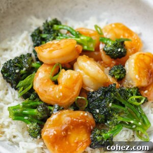 Close up shot of shrimp and broccoli stir fry on top of a bowl of rice
