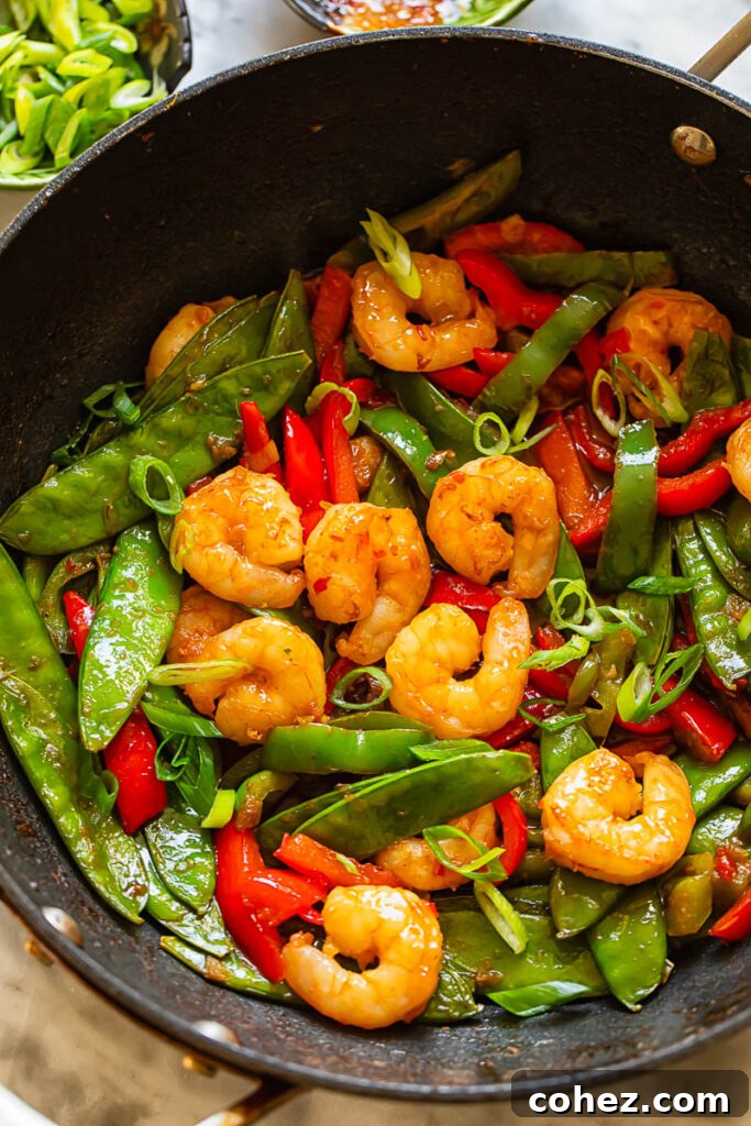 Sweet Heat Shrimp Stir-Fry 3 Top down shot of shrimp stir fry in a pan with veg topped with spring onions