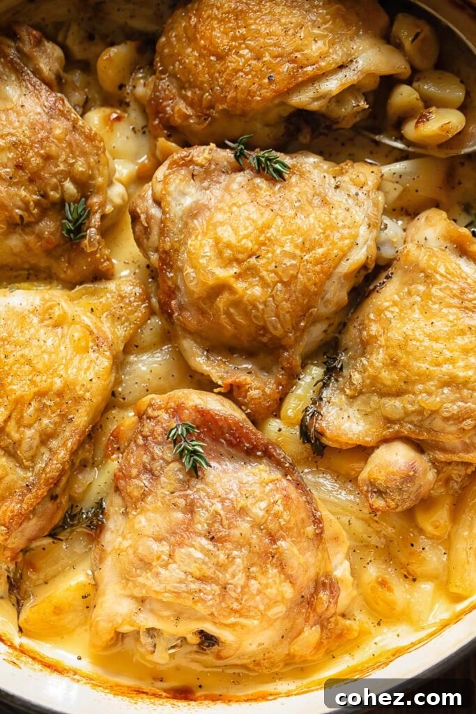 Close up shot of chicken thighs in a pan topped with rosemary garnish