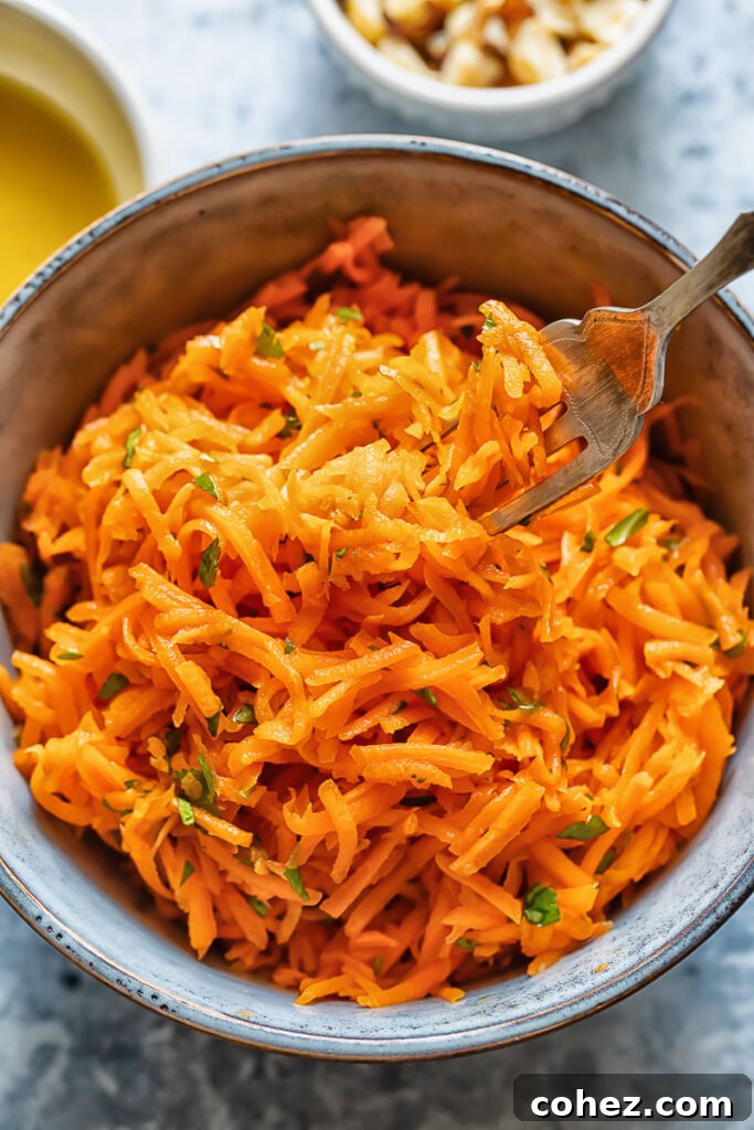 Close up shot of a bowl of french carrot salad with a fork