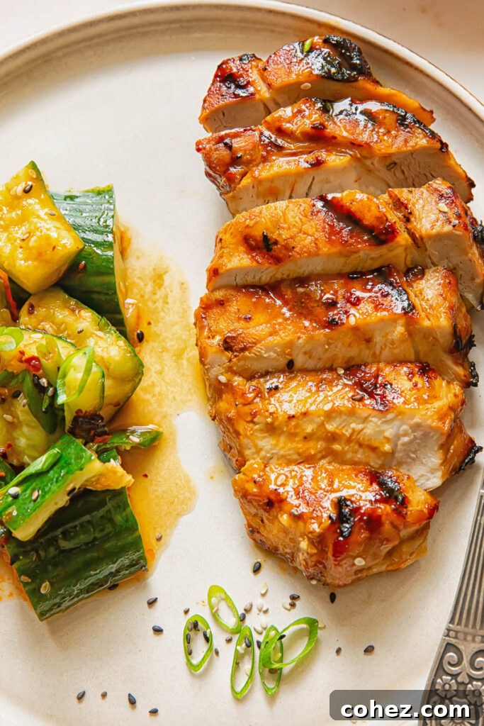 Flame Kissed Teriyaki Pork Chops 3 Sliced teriyaki pork chop next to a cucumber salad