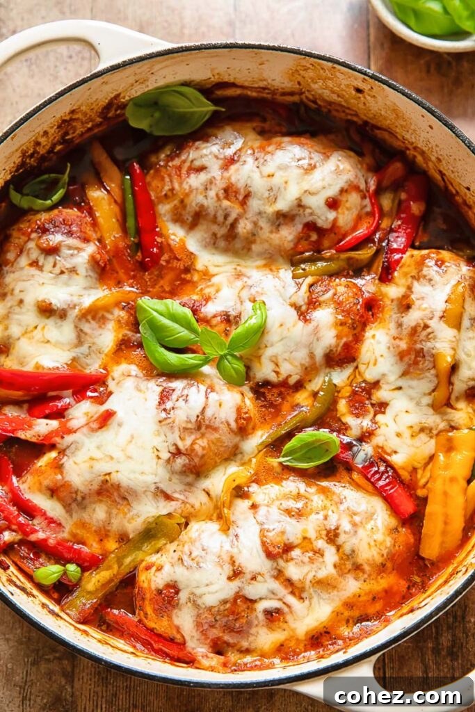 Top down shot of chicken marinara in a large pan, showcasing the rich tomato sauce, vibrant bell peppers, and melted mozzarella cheese, ready to be served as a comforting family meal.