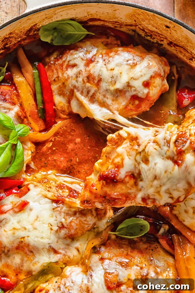 Close up of a bubbling, cheesy baked chicken marinara, with golden-brown melted mozzarella stretching over tender chicken and a rich marinara sauce.