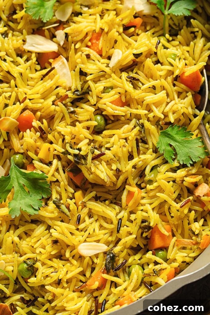 Close up of pilaf with peas, carrots and cilantro, garnished with fresh herbs
