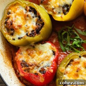 Italian sausage stuffed peppers in tomato sauce in a pan