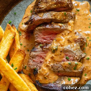 Steak Diane on a plate with fries and creamy sauce
