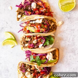 Ground Beef Tacos topped with salsa, avocado slices and red cabbage slaw