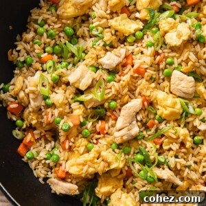 Fried rice with chicken, vegetables, and scrambled egg in a pan